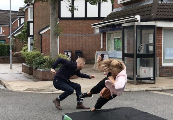 Gary saves Sarah from an oncoming car on Coronation Street